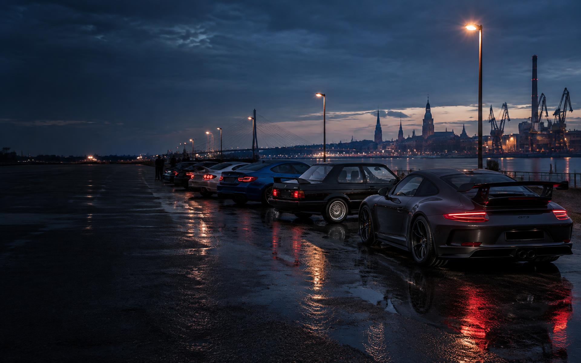 Enthusiast cars gathered beside the Riga waterfront at dusk